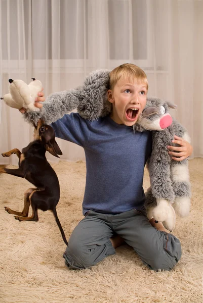 興奮して子供におもちゃと、カーペットの上犬 — ストック写真