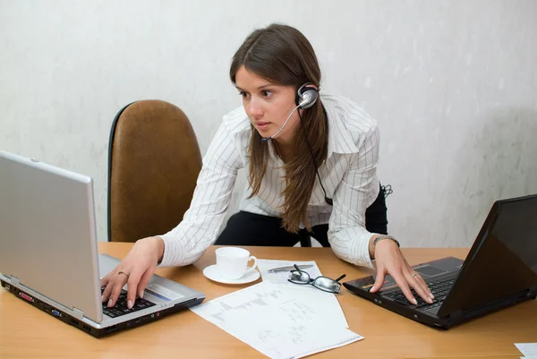 Jovem adolescente na mesa de escritório com laptops — Fotografia de Stock