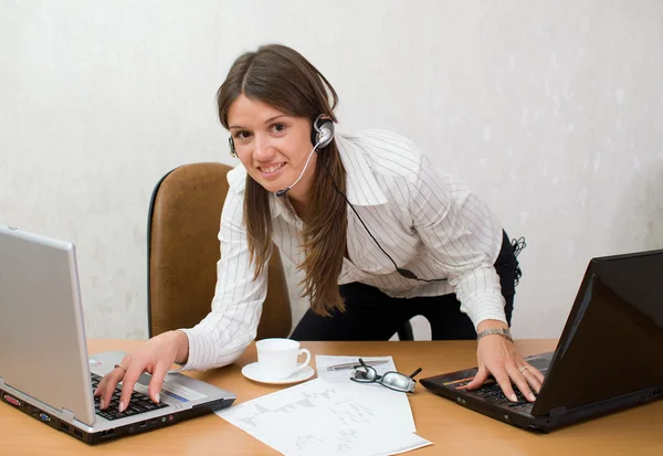 Chica inteligente rápida en el escritorio de la oficina con computadoras portátiles —  Fotos de Stock