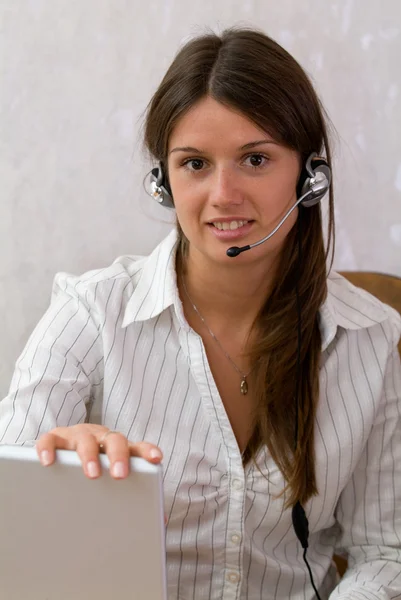 Kluge Geschäftsfrau mit Headset und Laptop — Stockfoto