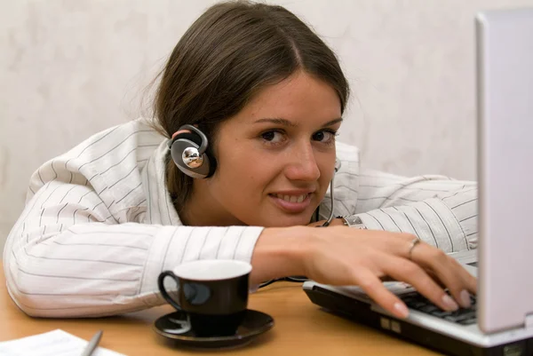 Beautiful student at the laptop with a headset — Stock Photo, Image
