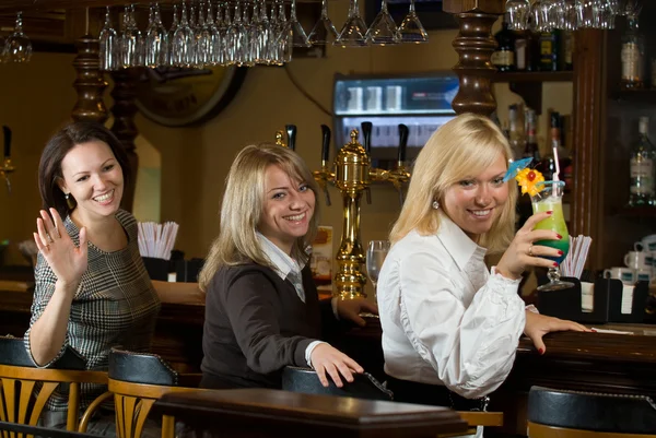 Three pretty girls at a bar counter — Stock Photo, Image