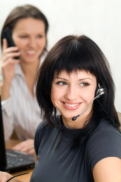 Jonge brunette met een headset in het bedrijfsleven — Stockfoto