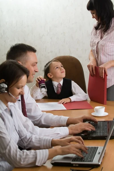 Мальчик в качестве начальника офиса с сотрудниками — стоковое фото