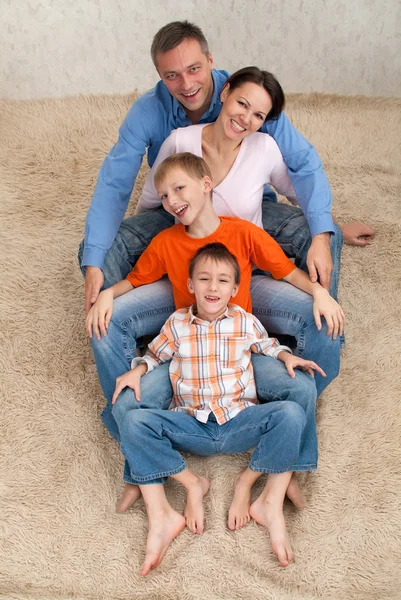 흰 카펫에 앉아 가족 — 스톡 사진