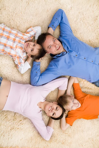 Family lying on the carpet — Stock Photo, Image