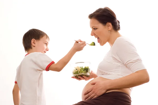 Filho para alimentar sua mãe grávida — Fotografia de Stock
