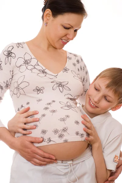 Filho abraçando mães grávidas estômago — Fotografia de Stock