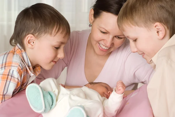 Glückliche junge Mutter mit drei Kindern — Stockfoto
