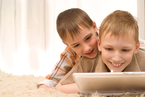 Deux petits frères couchent avec un ordinateur portable — Photo