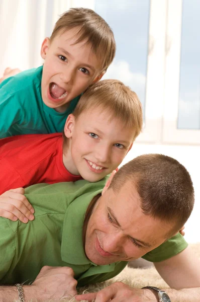 Ojciec i dwóch młodych braci leżącego — Zdjęcie stockowe