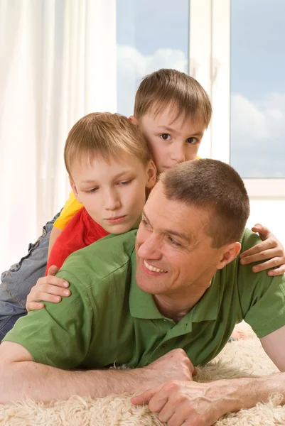 Father and two young brothers lying — Stock Photo, Image