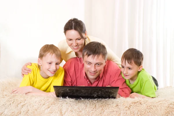 Τετραμελής οικογένεια με ένα φορητό υπολογιστή — Φωτογραφία Αρχείου