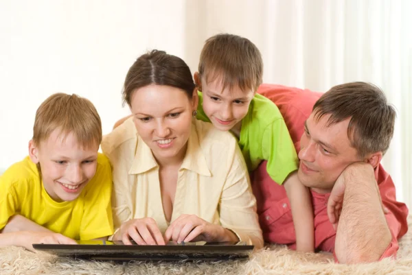 Familj på fyra med en bärbar dator — Stockfoto