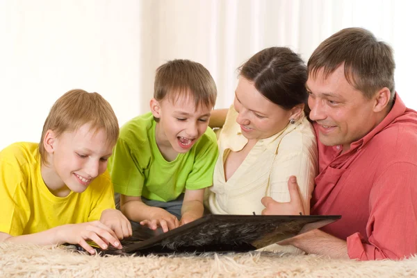 Famiglia di quattro persone con un portatile — Foto Stock