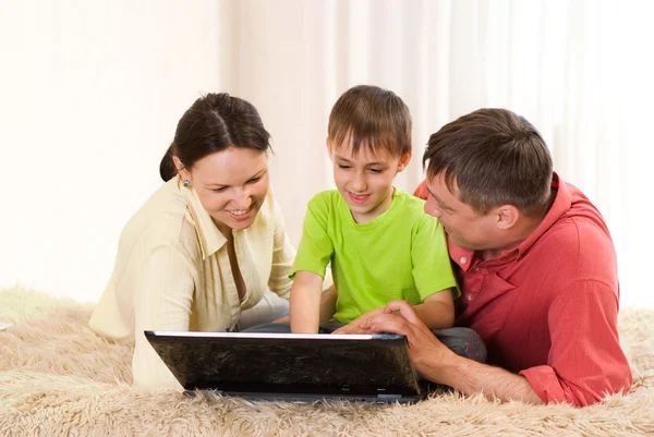 Familia de tres con un ordenador portátil — Foto de Stock
