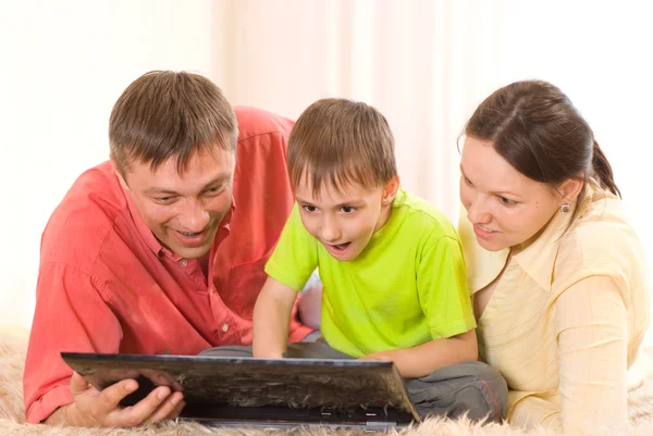 Familia de tres con un ordenador portátil — Stockfoto