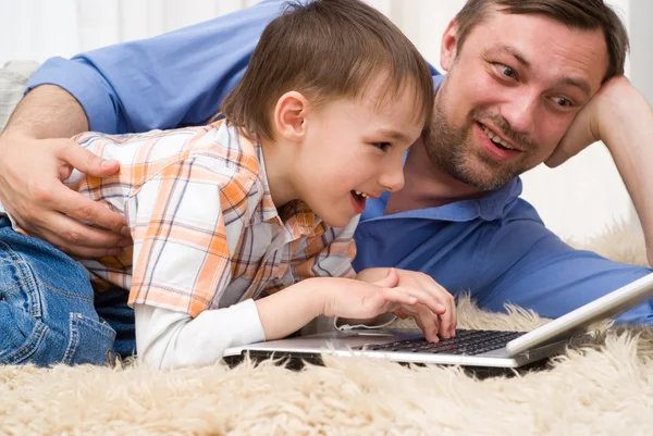 Pai e filho com laptop Imagens Royalty-Free
