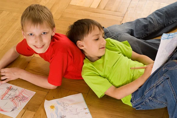 Two brothers lying and draw — Stockfoto