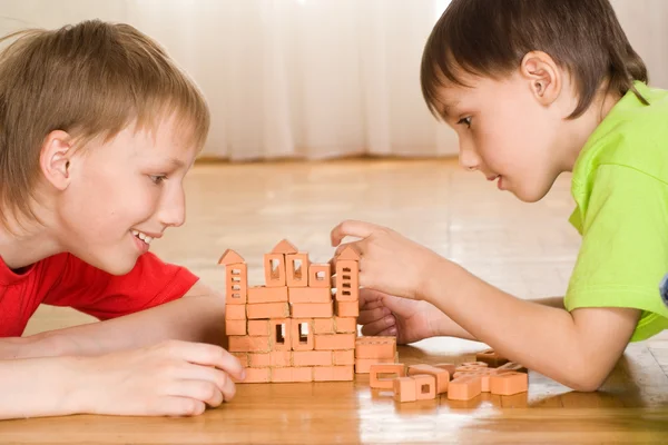 Brothers are building of a toy castle — Stock Photo, Image