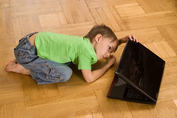 男孩窥视一台笔记本电脑 — 图库照片
