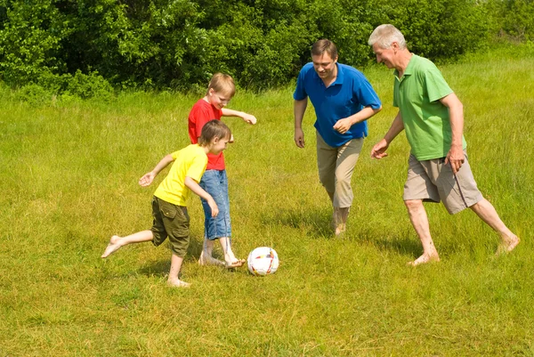 Família feliz jogando futebol — Fotografia de Stock