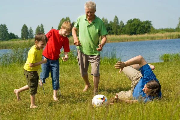 Ευτυχισμένη οικογένεια παίζει ποδόσφαιρο — Φωτογραφία Αρχείου