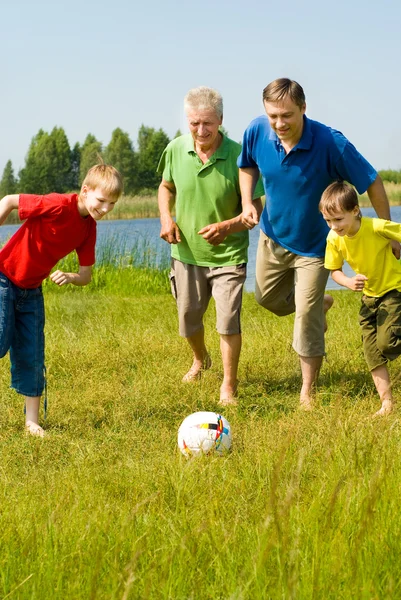 Familia feliz jugando fútbol — Foto de Stock