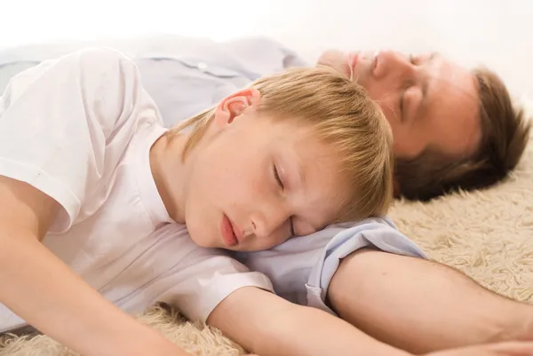 Tata i syn, spanie na dywanie — Zdjęcie stockowe