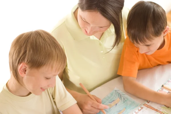 Giovane madre disegna con i suoi figli — Foto Stock