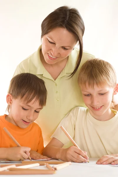 Giovane madre disegna con i figli — Foto Stock