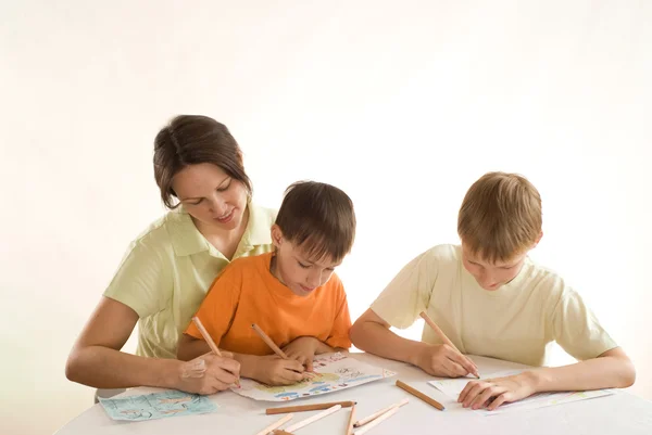 Joven madre dibuja con sus hijos — Foto de Stock