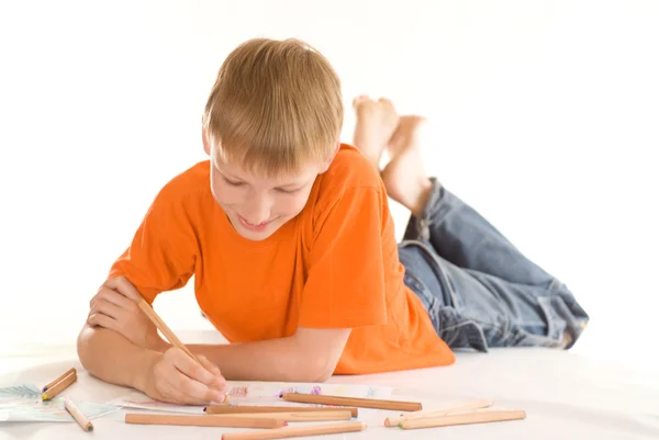 Junge lügt und zeichnet — Stockfoto