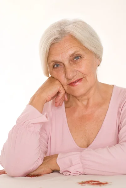 Ältere Frau auf einem weißen — Stockfoto
