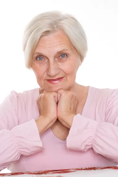 Smiling old women at the desk — Stock Photo, Image
