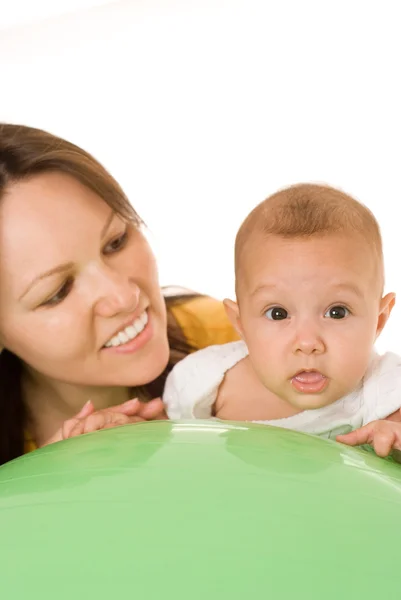Anne bebek üzerinde yeşil bir balon tutuyor. — Stok fotoğraf