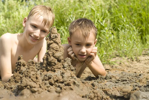 Two children build a sand castle — Stock Photo, Image