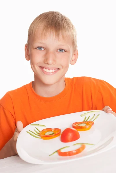 Beautiful boy holding a plate with vegetables — Stock Photo, Image