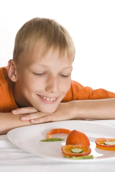 Schöner Junge mit einem Teller mit Gemüse — Stockfoto