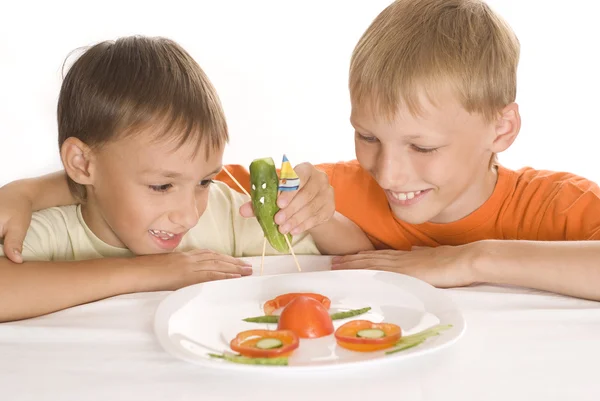 Belos meninos segurando um prato com legumes — Fotografia de Stock