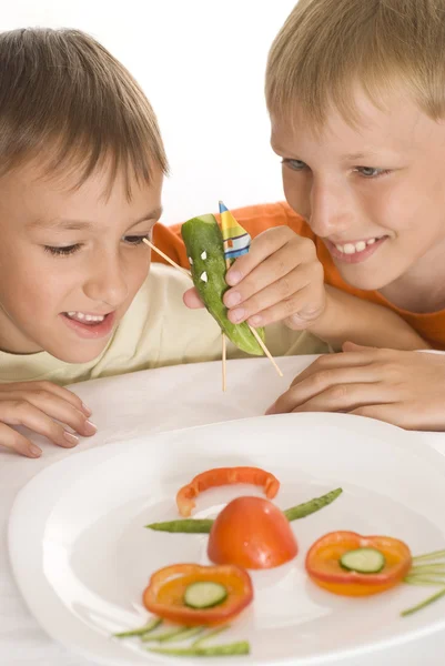 Belos meninos segurando um prato com legumes — Fotografia de Stock