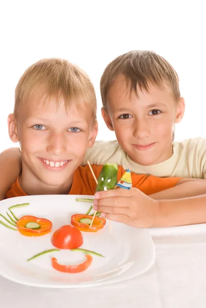 Garçons tenant une assiette avec des légumes — Photo