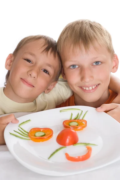 Jungen halten einen Teller auf weiß — Stockfoto
