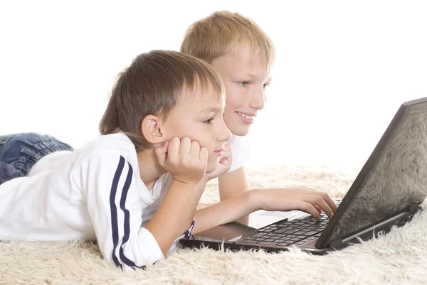 Twee broers liggen met laptop — Stockfoto