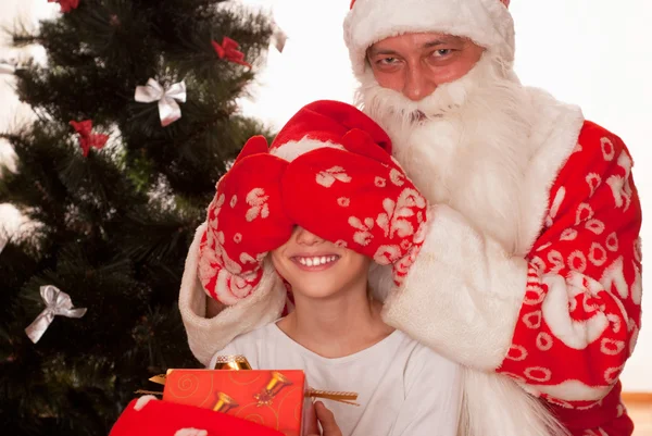 Papai Noel dá presentes para menino — Fotografia de Stock