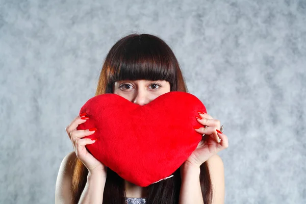 Kırmızı kalp tutan güzel genç kadın — Stok fotoğraf