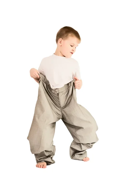 Een jongen in vaders broek — Stockfoto