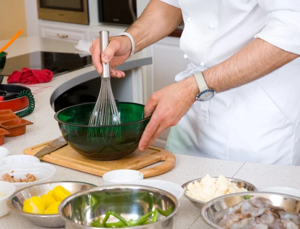 Professional chef hands with kitchen utensils whisk and pan — Stock Photo, Image