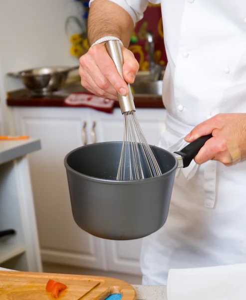 Mãos de chef profissional com utensílios de cozinha batem e panela — Fotografia de Stock