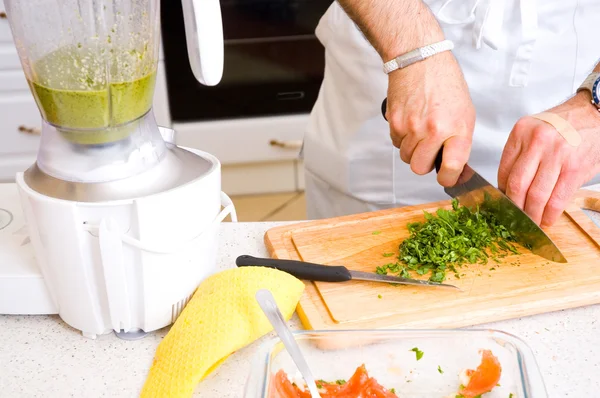 Chef cutting the parsley on a wooden board — Stock Photo, Image